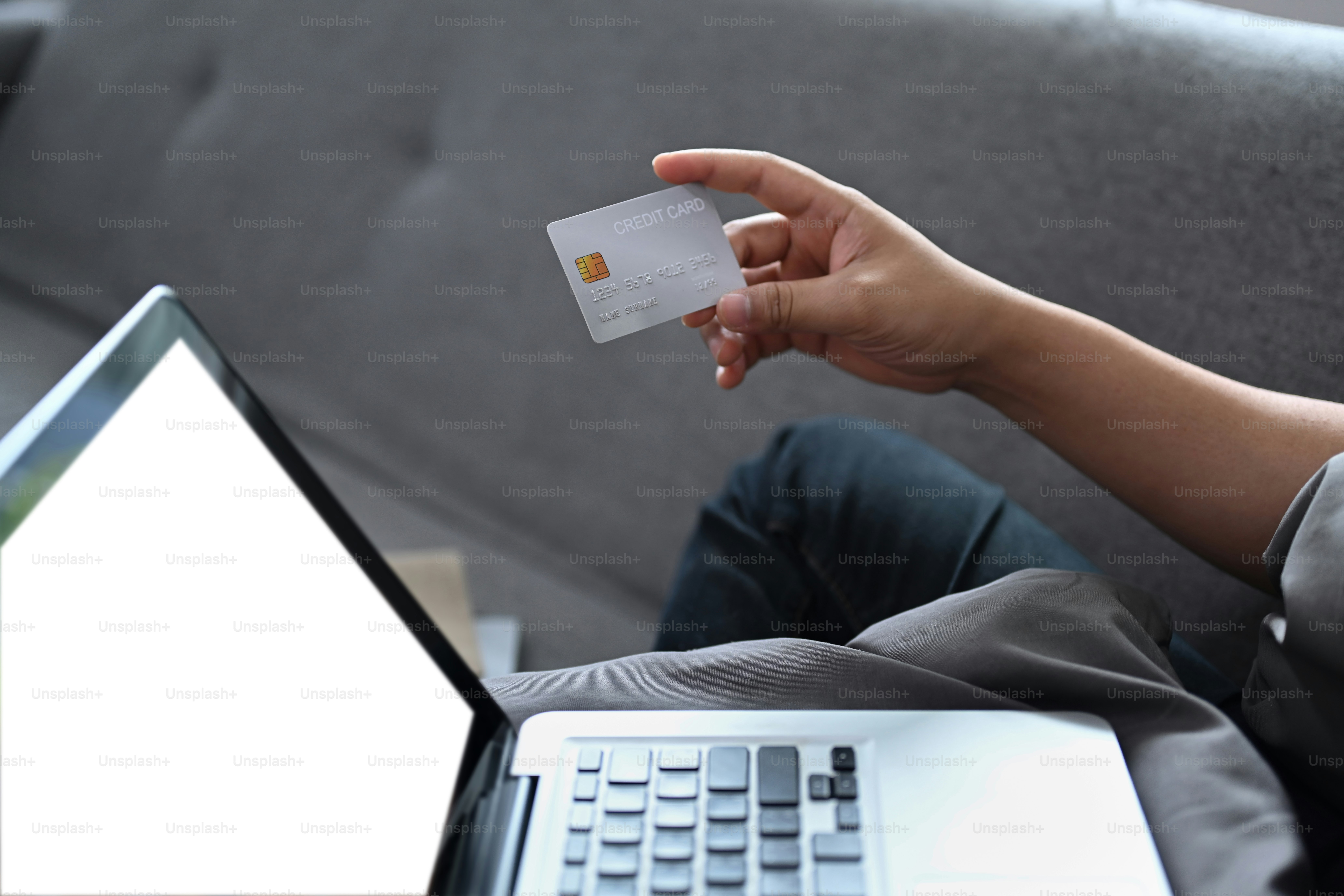 Asian man sitting in living room and having video call on laptop computer.